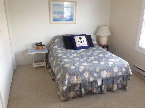 a bed sitting in a bedroom next to a window