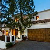 a front view of a house with a tree