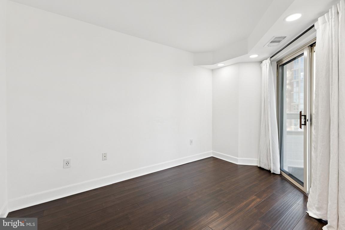 2151 Jamieson Avenue, Unit 1002 Alexandria, VA 22314 - Photo 14 of 25 a view of an empty room with wooden floor and a window