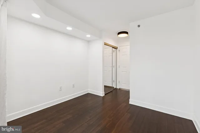 an empty room with wooden floor and a window