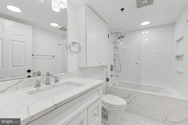 a bathroom with a sink toilet vanity and shower