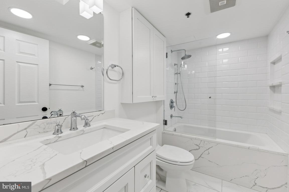 2151 Jamieson Avenue, Unit 1002 Alexandria, VA 22314 - Photo 21 of 25 a bathroom with a sink toilet vanity and shower