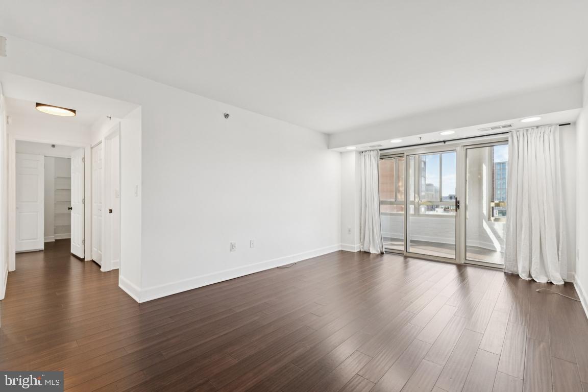 2151 Jamieson Avenue, Unit 1002 Alexandria, VA 22314 - Photo 3 of 25 a view of an empty room with wooden floor and a window