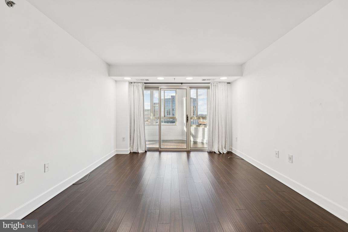2151 Jamieson Avenue, Unit 1002 Alexandria, VA 22314 - Photo 4 of 25 an empty room with wooden floor and windows