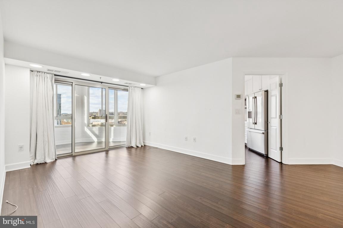 2151 Jamieson Avenue, Unit 1002 Alexandria, VA 22314 - Photo 5 of 25 a view of an empty room with wooden floor and a window