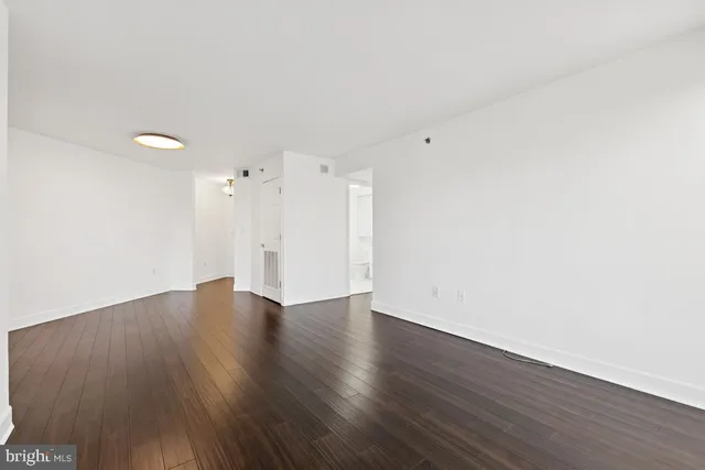 a view of an empty room with wooden floor