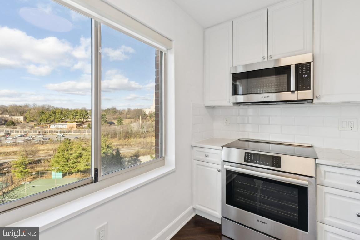 2151 Jamieson Avenue, Unit 1002 Alexandria, VA 22314 - Photo 10 of 25 a kitchen with stainless steel appliances wooden cabinets and a stove top oven