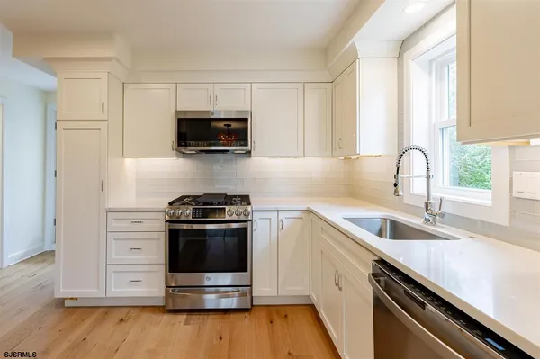 a kitchen with a sink stove and microwave