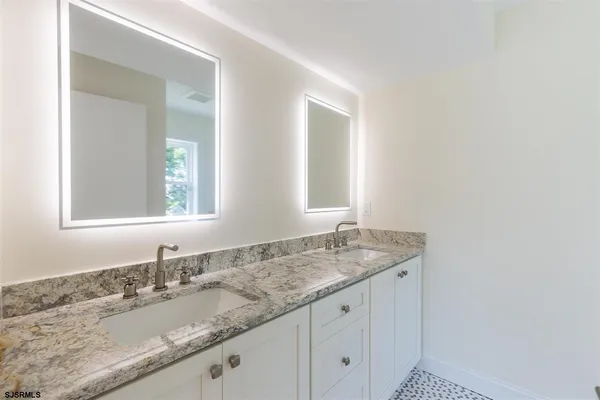 a bathroom with a granite countertop sink and a mirror