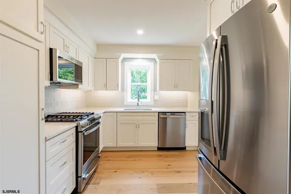 a kitchen with kitchen island a sink stove and refrigerator