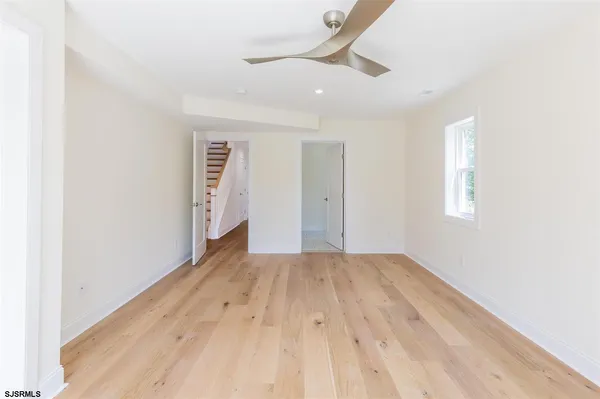 a view of a big room with wooden floor and windows in a room