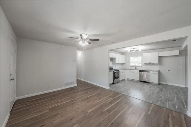 a view of a kitchen with a sink wooden cabinets and window