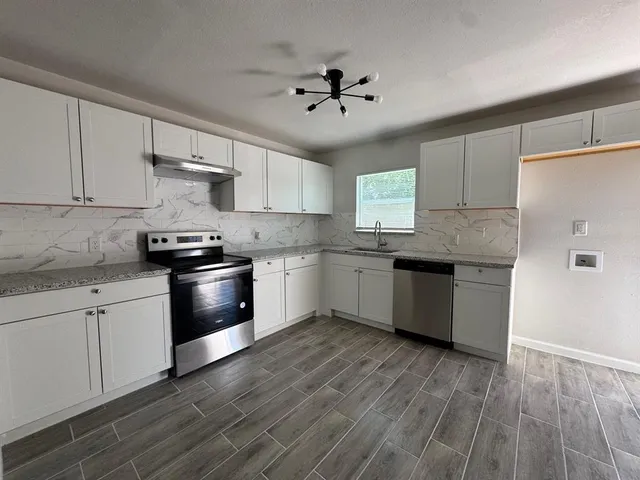 a kitchen with granite countertop white cabinets and white appliances