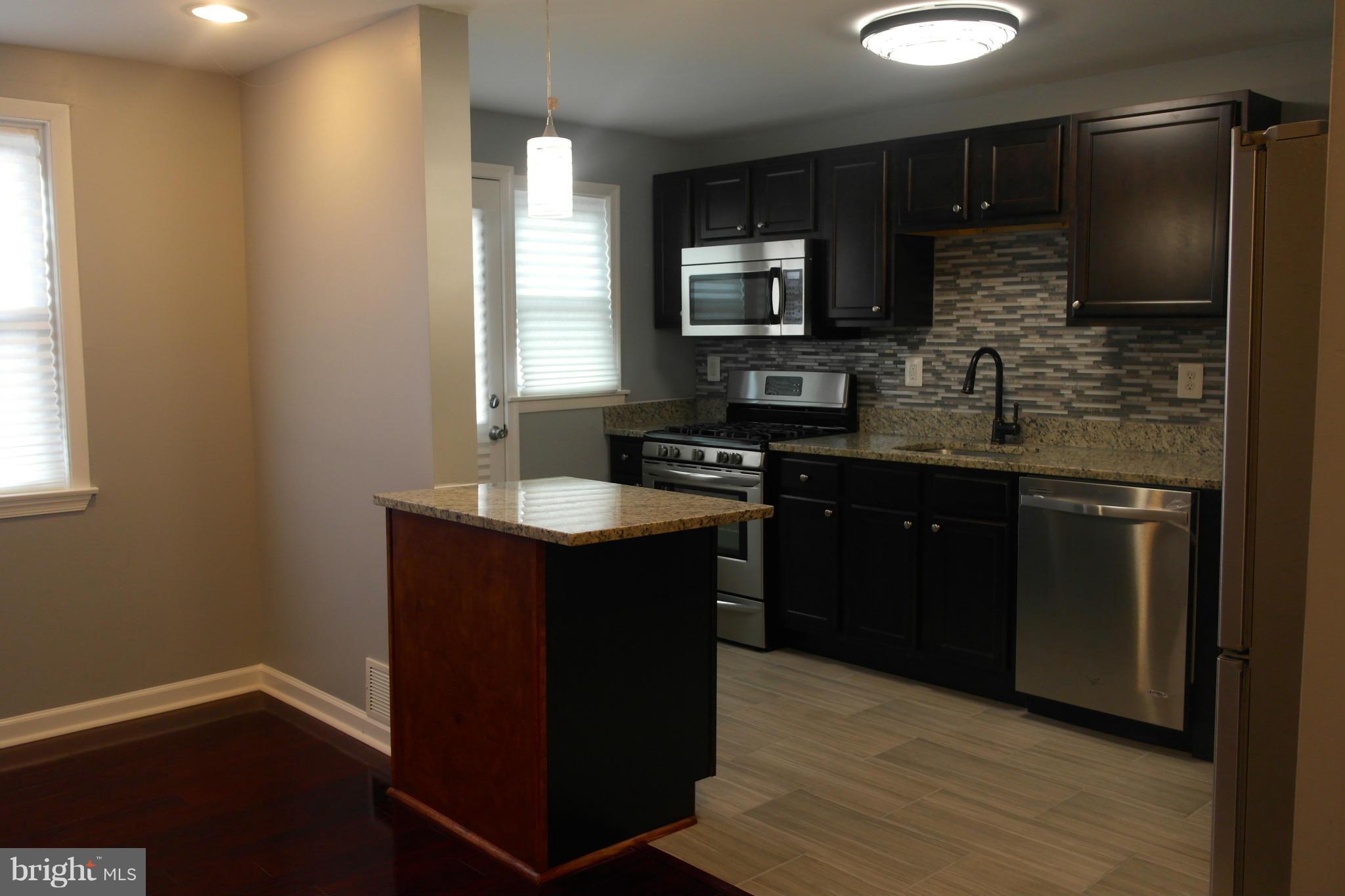 1225 Wicklow Road Baltimore, MD 21229 - Photo 7 of 17 a kitchen with a sink stove and refrigerator