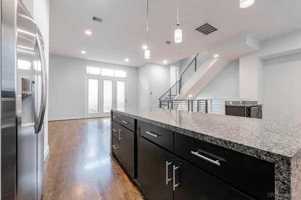 a kitchen with stainless steel appliances granite countertop a sink a stove and a refrigerator