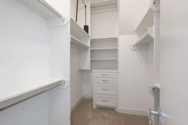a view of walk in closet with empty racks