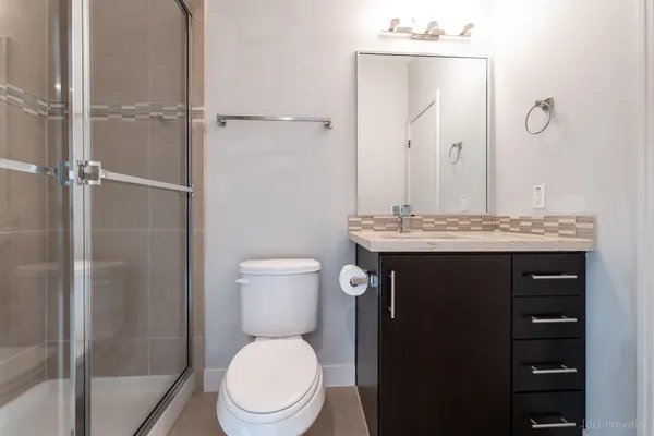 a bathroom with a granite countertop toilet sink and a mirror