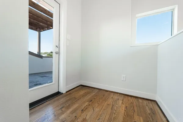 an empty room with wooden floor and a window