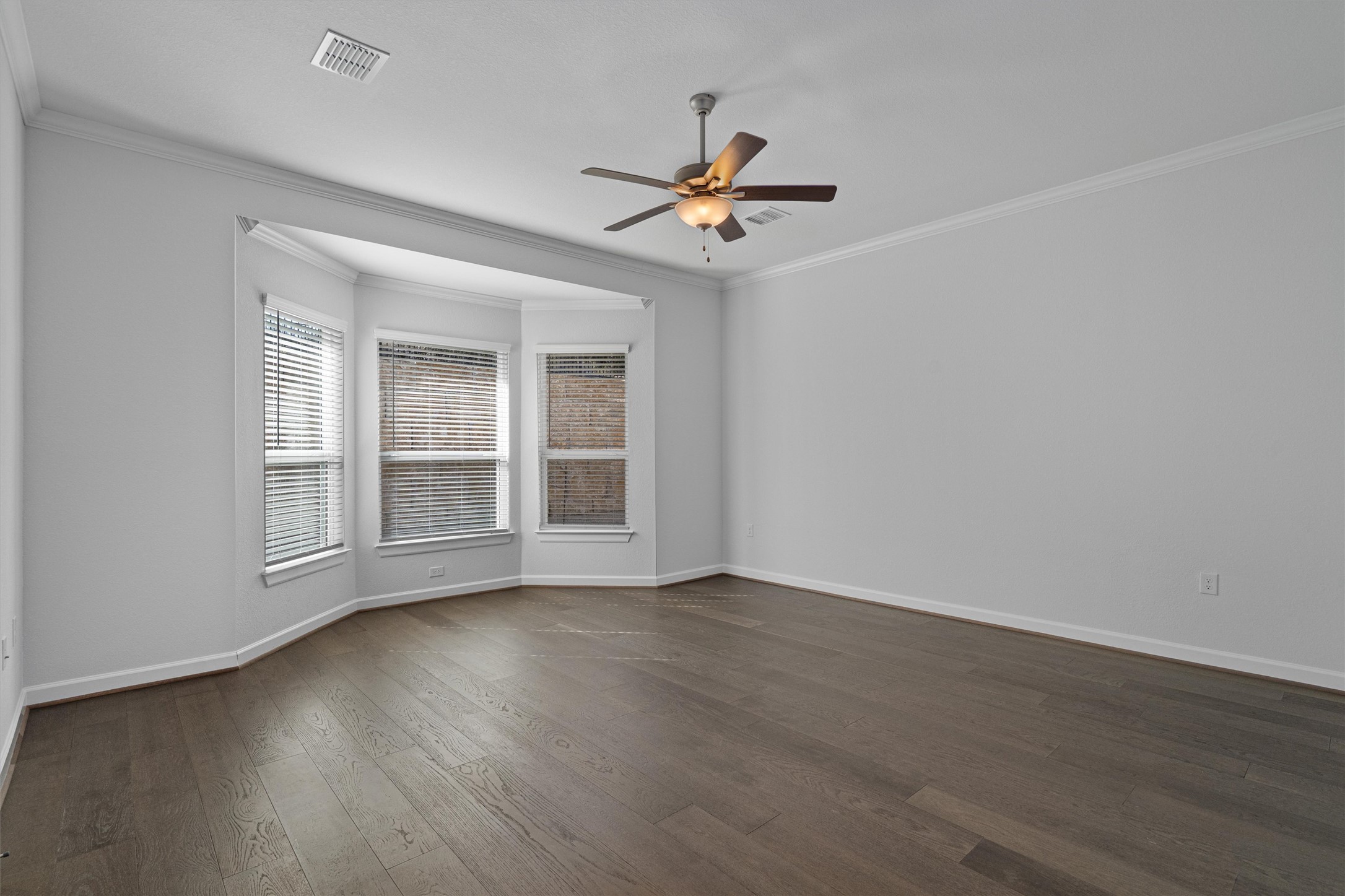 208 Lodestone Lane Austin, TX 78738 - Photo 12 of 38 Empty room with ceiling fan, ornamental molding, and dark wood finished floors