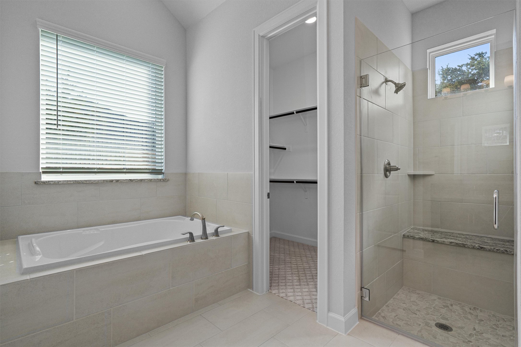 208 Lodestone Lane Austin, TX 78738 - Photo 15 of 38 Bathroom featuring a walk in closet, a bath, a stall shower, and light tile patterned floors