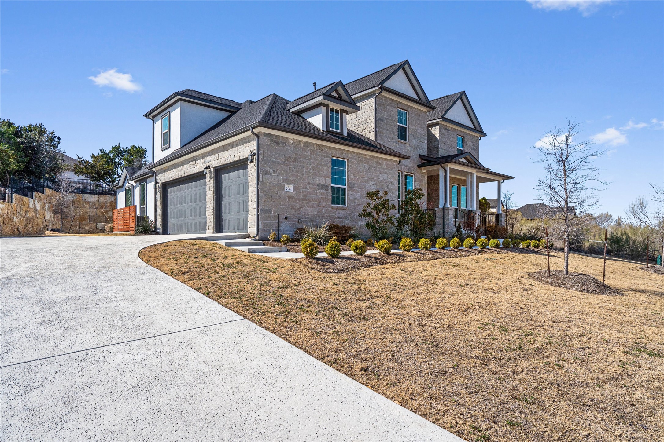 208 Lodestone Lane Austin, TX 78738 - Photo 2 of 38 View of front of home with stone siding, driveway, and a front yard