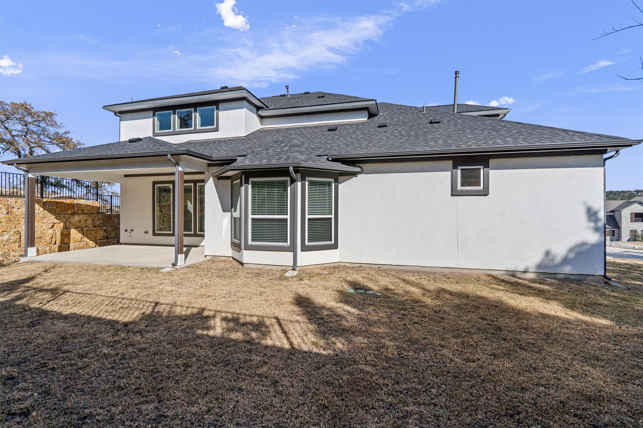 208 Lodestone Lane Austin, TX 78738 - Photo 33 of 38 Back of property featuring a patio area, roof with shingles, and stucco siding