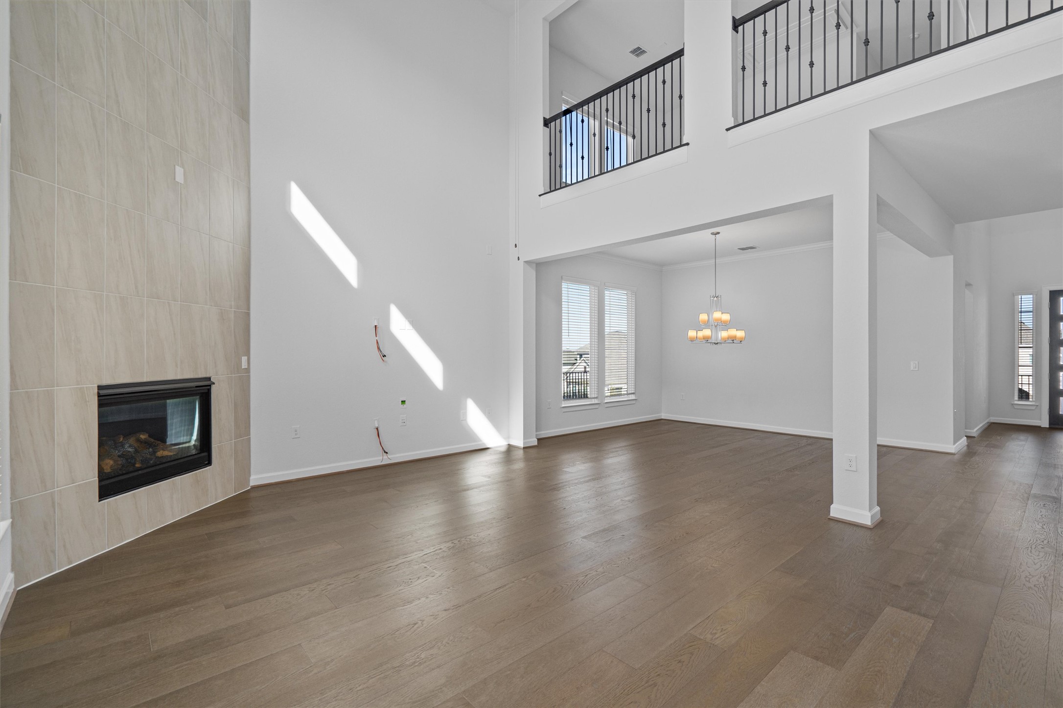 208 Lodestone Lane Austin, TX 78738 - Photo 8 of 38 Unfurnished living room with a fireplace, a high ceiling, dark wood-style flooring, and suspended lighting