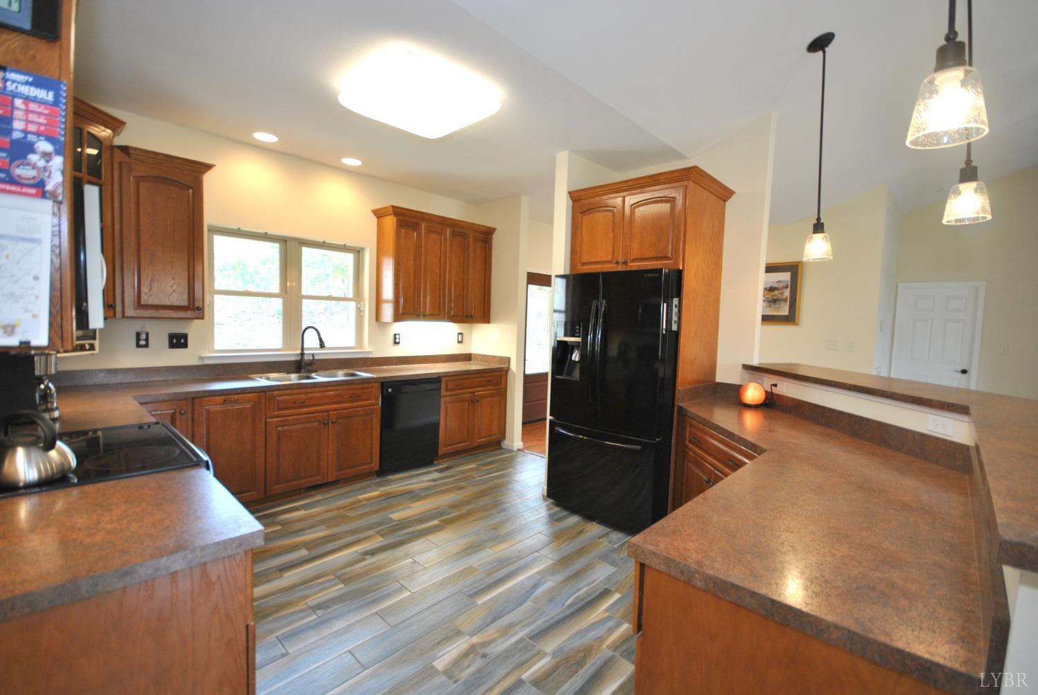 1206 East Perch Road Monroe, VA 24574 - Photo 23 of 83 a kitchen with stainless steel appliances granite countertop a refrigerator a sink dishwasher a stove with wooden floor and cabinets