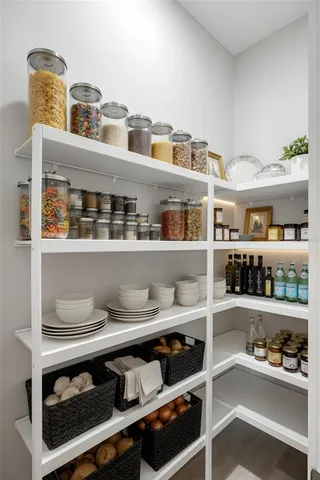 a kitchen with white cabinets and chairs