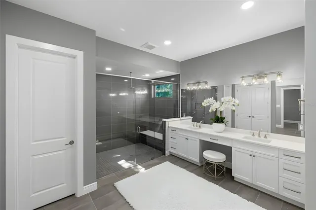 a bathroom with a double vanity sink a mirror and a bathtub
