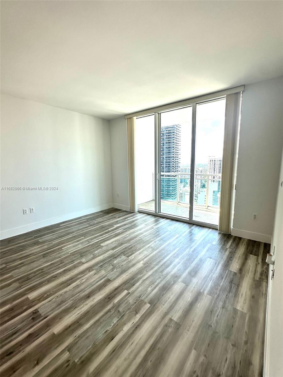 951 Brickell Avenue, Unit 3403 Miami, FL 33131 - Photo 19 of 26 a view of an empty room with wooden floor and a window