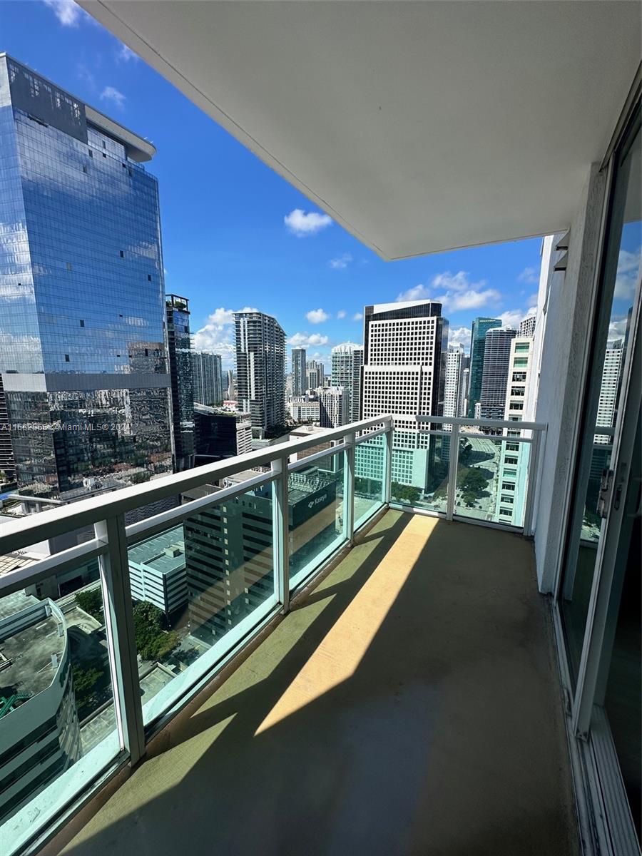 951 Brickell Avenue, Unit 3403 Miami, FL 33131 - Photo 24 of 26 a view of a balcony with floor to ceiling windows with wooden floor