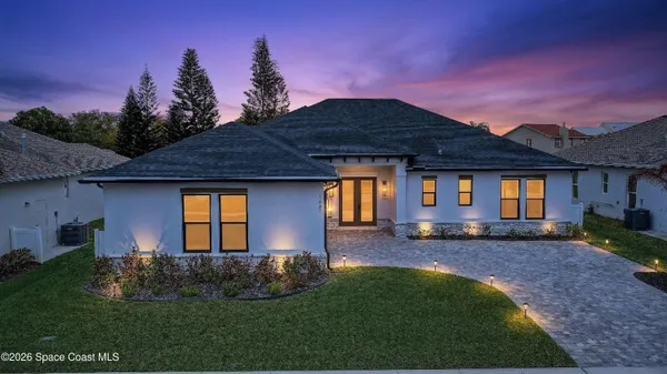 a front view of a house with a garden and yard