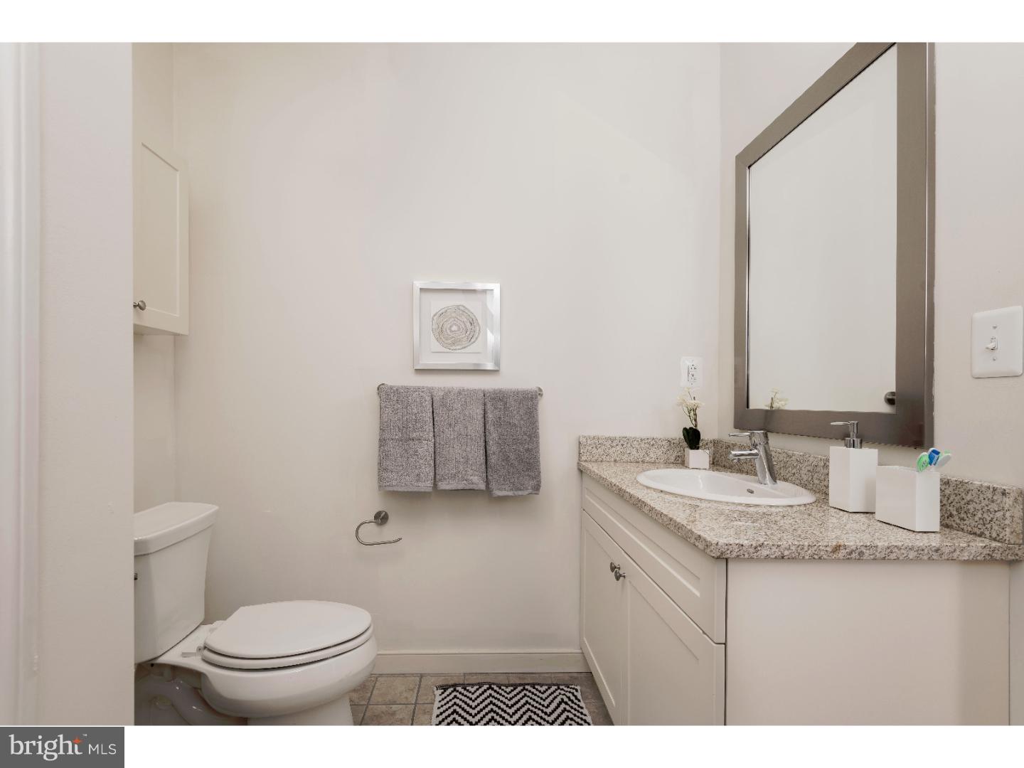 1900-20 Arch Street, Unit 1017 Philadelphia, PA 19103 - Photo 8 of 30 a bathroom with a granite countertop sink mirror vanity and toilet