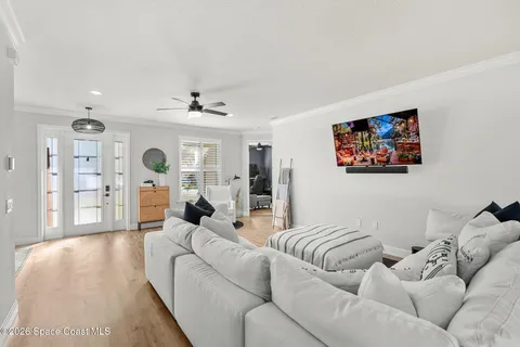 a living room with couches and a view of kitchen