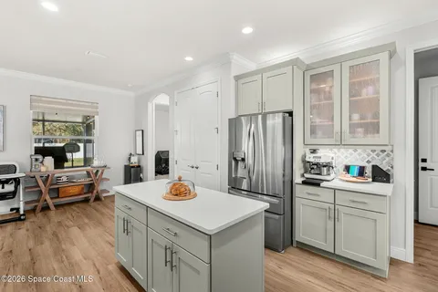 a large kitchen with a sink and refrigerator