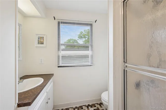 a bathroom with a granite countertop sink toilet and shower