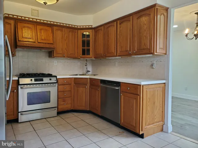 a kitchen with stainless steel appliances granite countertop a refrigerator and a stove