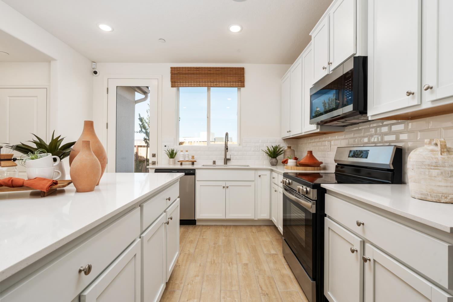 1532 Redbrick Lane Clovis, CA 93619 - Photo 13 of 33 a kitchen with stainless steel appliances white cabinets a sink and a stove