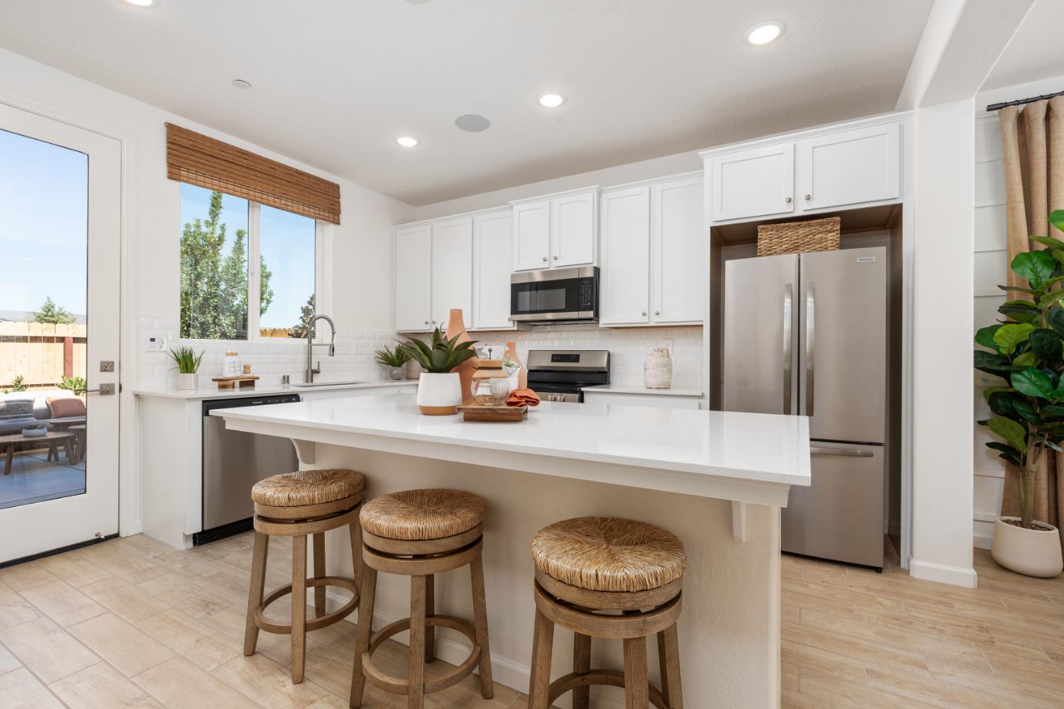 1532 Redbrick Lane Clovis, CA 93619 - Photo 9 of 33 a kitchen with sink refrigerator dining table and chairs