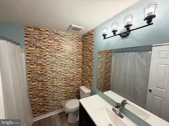 a bathroom with a sink a toilet and shower curtain