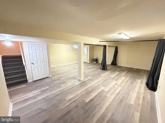 a view of empty room with wooden floor and window