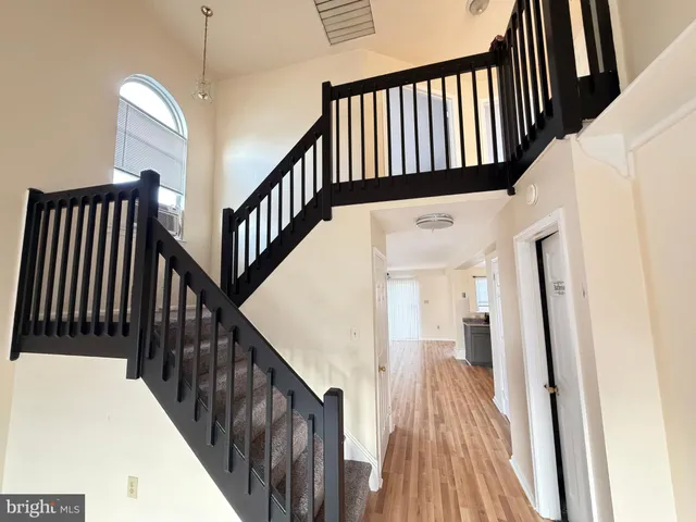 a view of staircase with lots of frames on wall and wooden floor