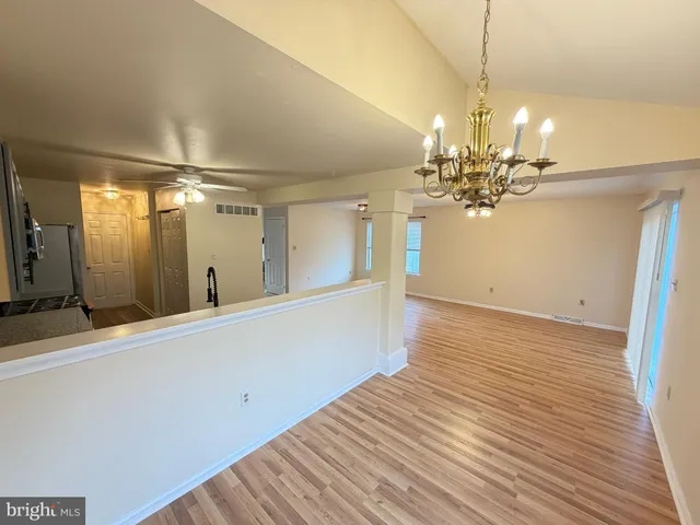 a view of a room with wooden floor and chandelier