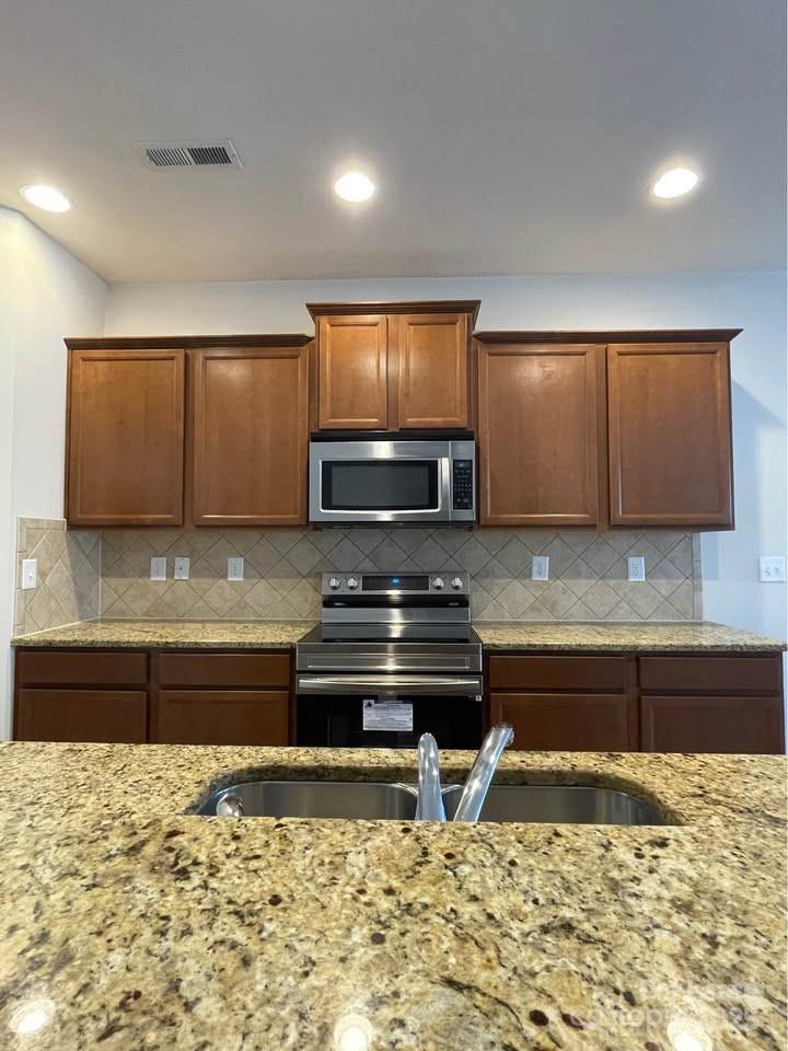 8715 Balsam Bay Road Charlotte, NC 28227 - Photo 4 of 15 a kitchen with a stove a sink and a microwave