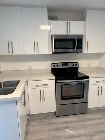 a kitchen with white cabinets and stainless steel appliances