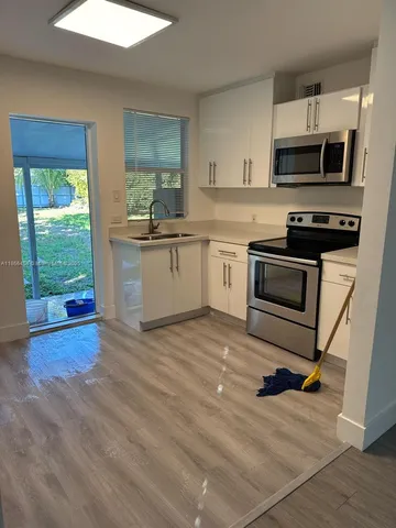 a kitchen with a sink appliances and cabinets