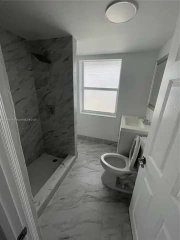 a bathroom with a shower a toilet and sink