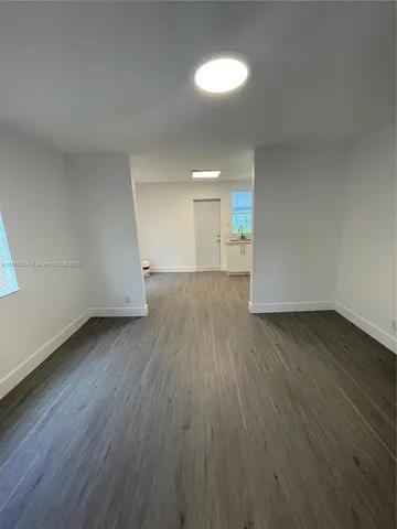 a view of a room with wooden floor and white walls