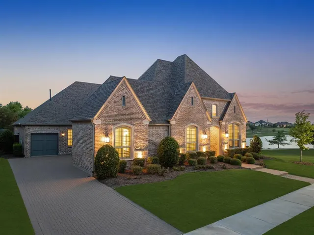 a front view of a house with a yard and trees